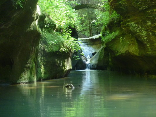 a waterfall plunges into a swimming area