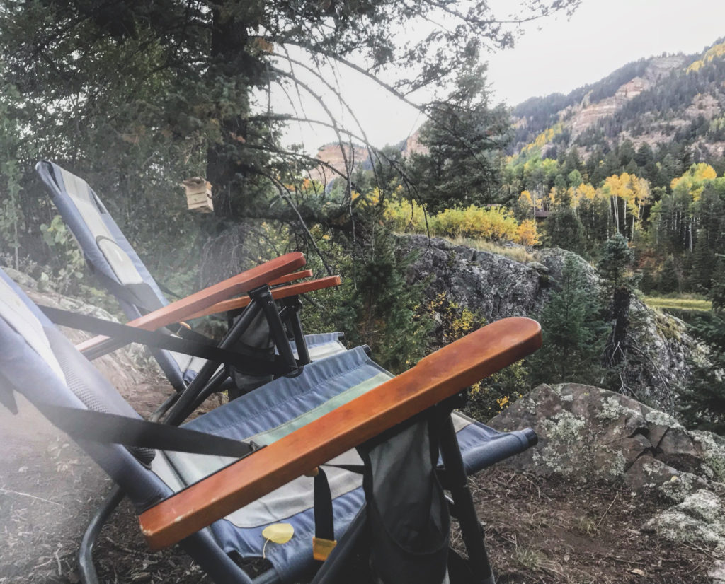 two camping chairs on a cliff in the forest