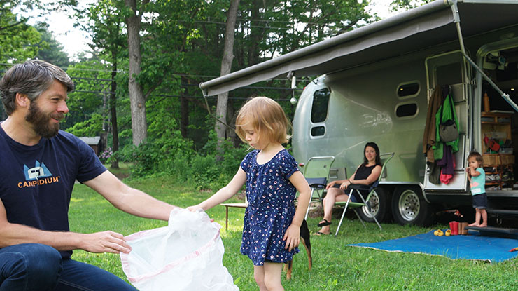 family picking up litter around their campsite