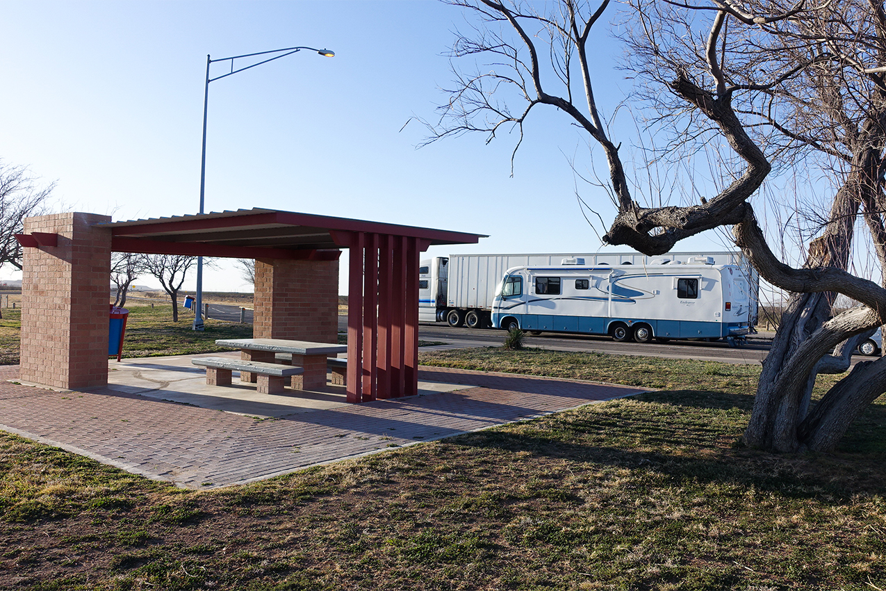 RV parked next to picnic shelter.
