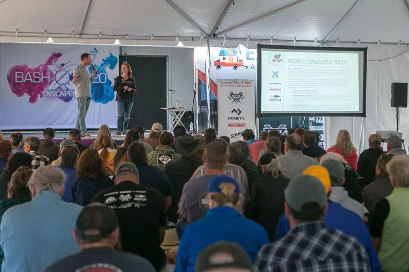 Two speakers giving a presentation to a large audience.