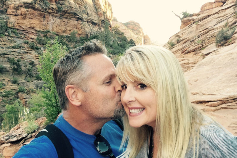 Man kissing woman on the cheek in the outdoors