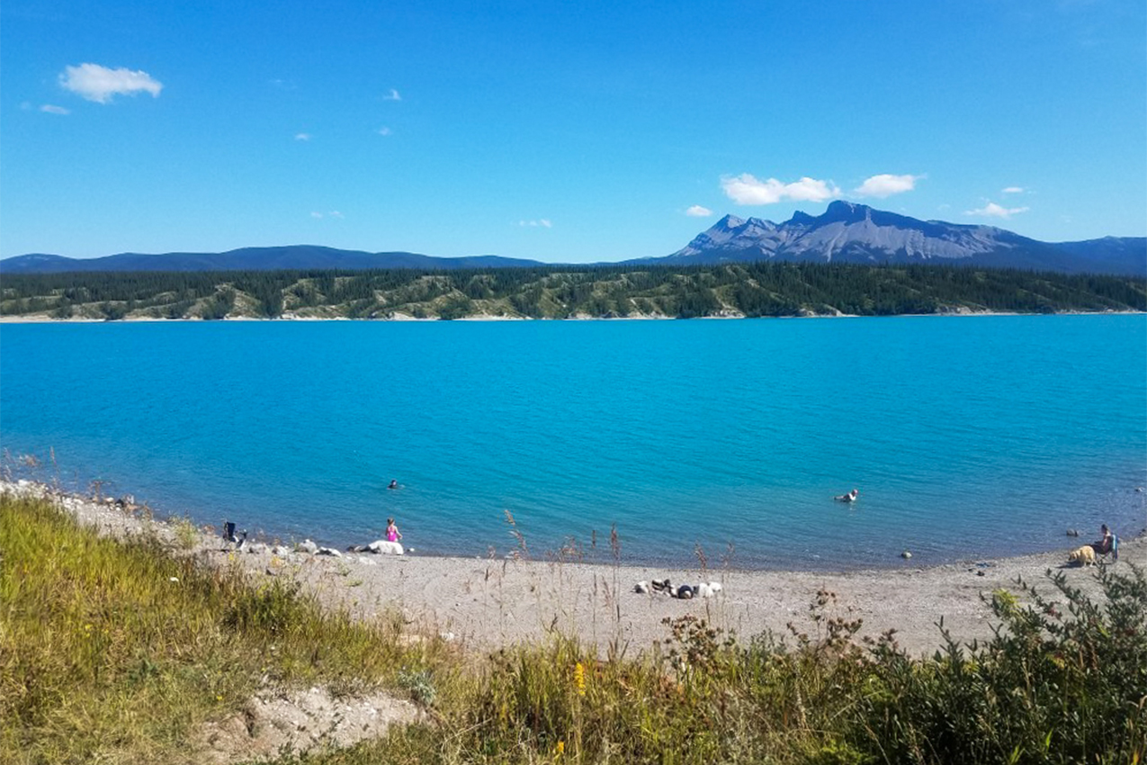 Blue lake with people on the beach.