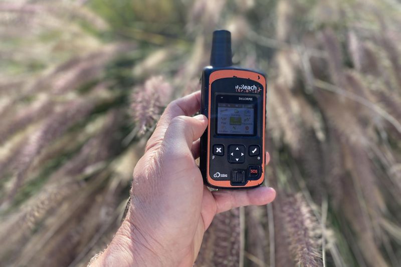 A hand holding the Garmin InReach