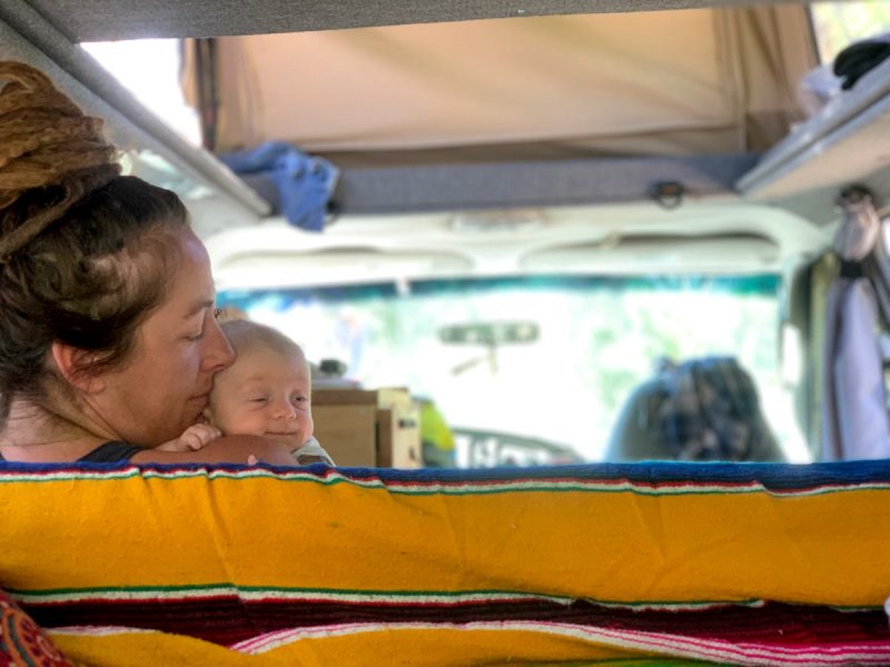 a mom holds her newborn in a Sportsmobile