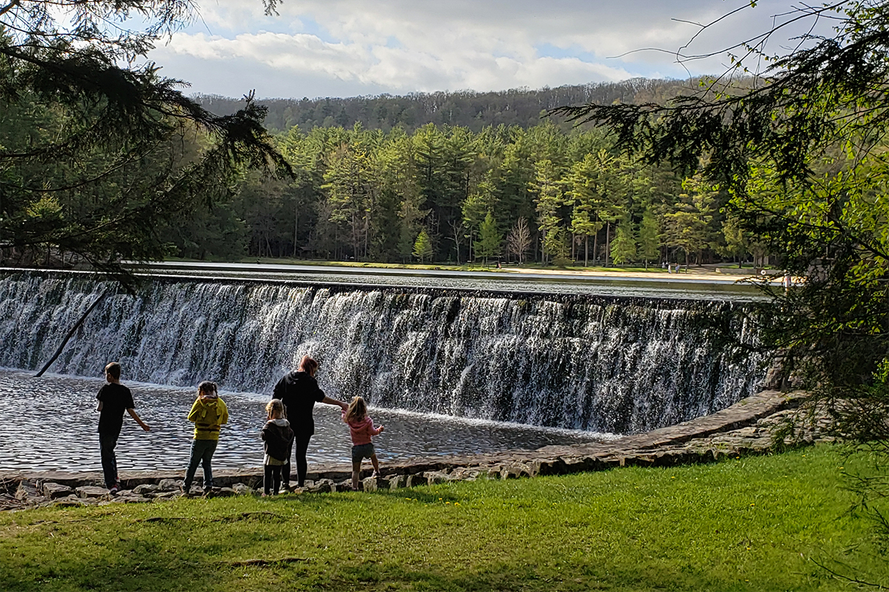 Family of five standing in front of a waterfall.
