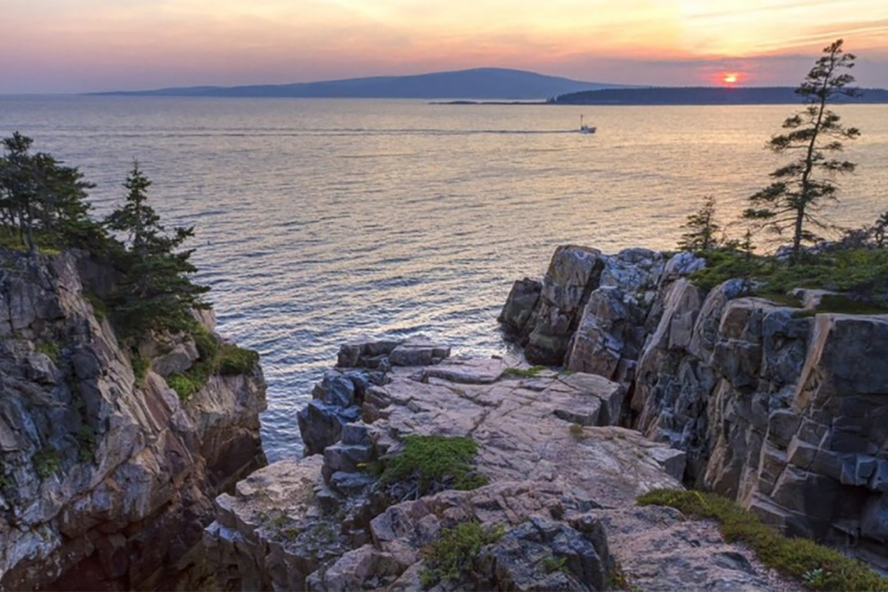 Sunset over cliffs and water.