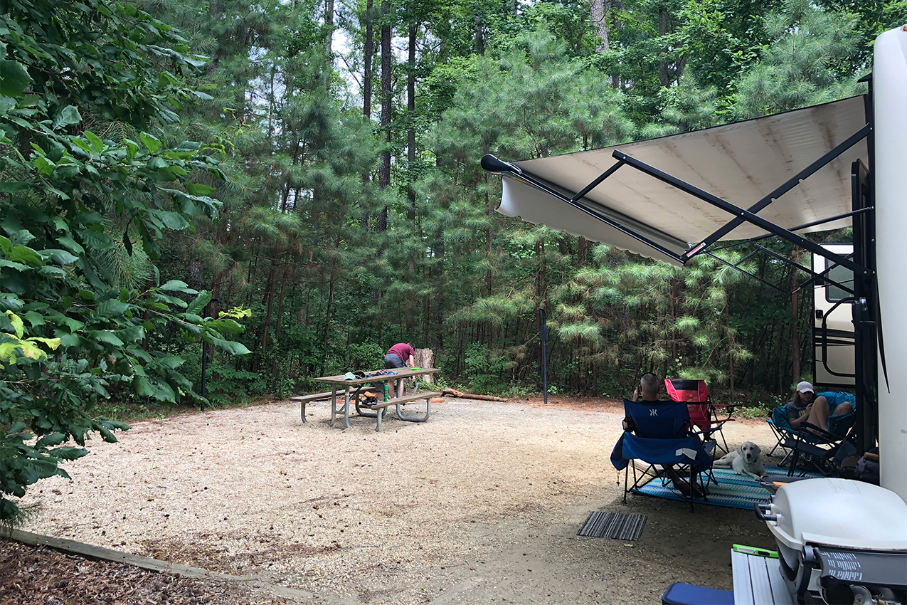 People hanging outside next to their RV.