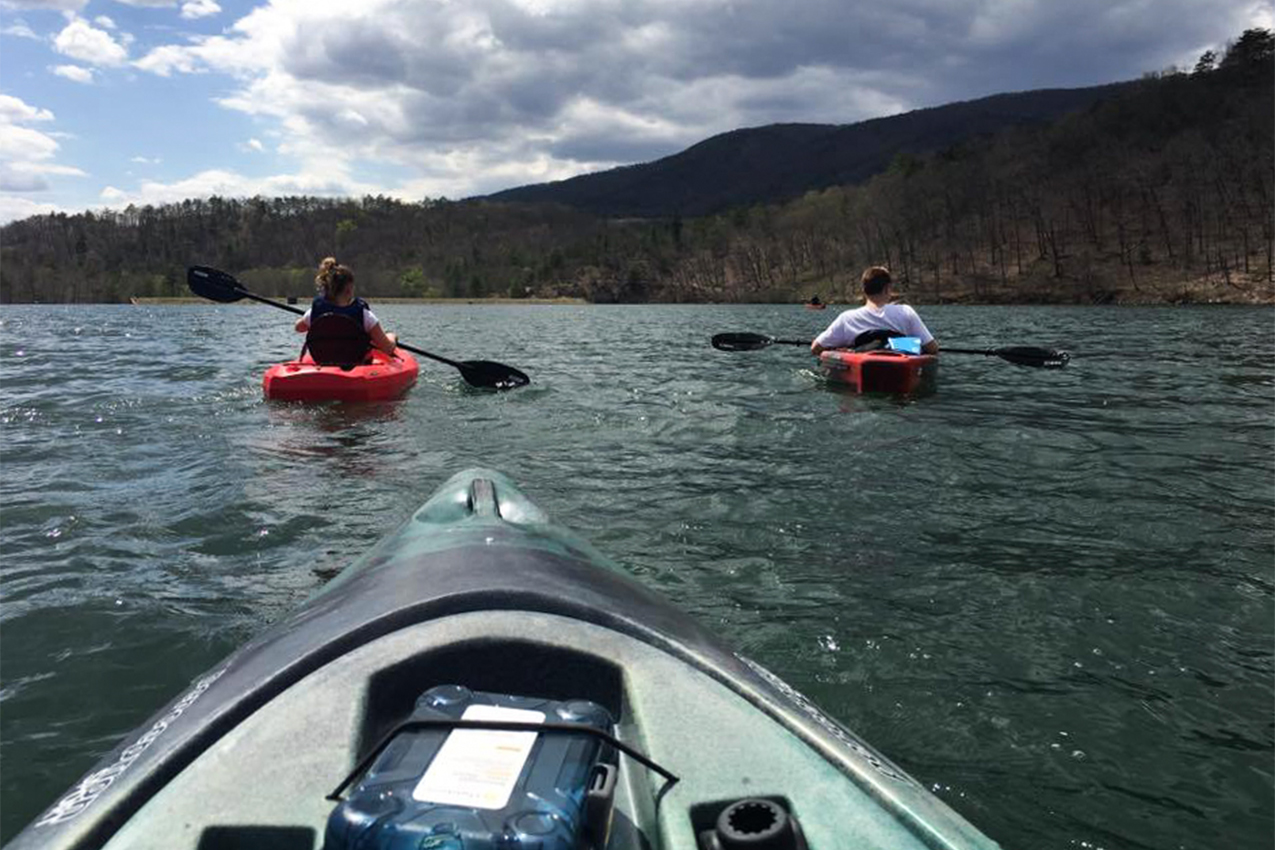 Three kayakers paddling in a lake.