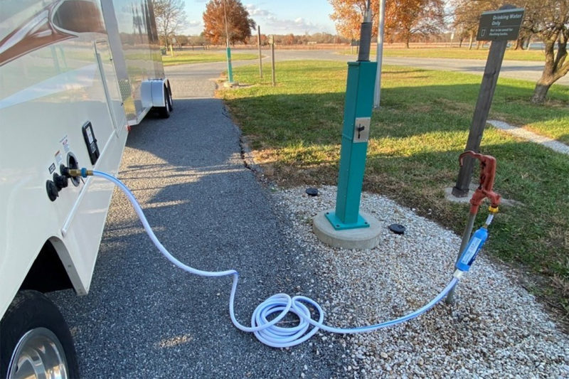 RV getting fresh water at dump station.