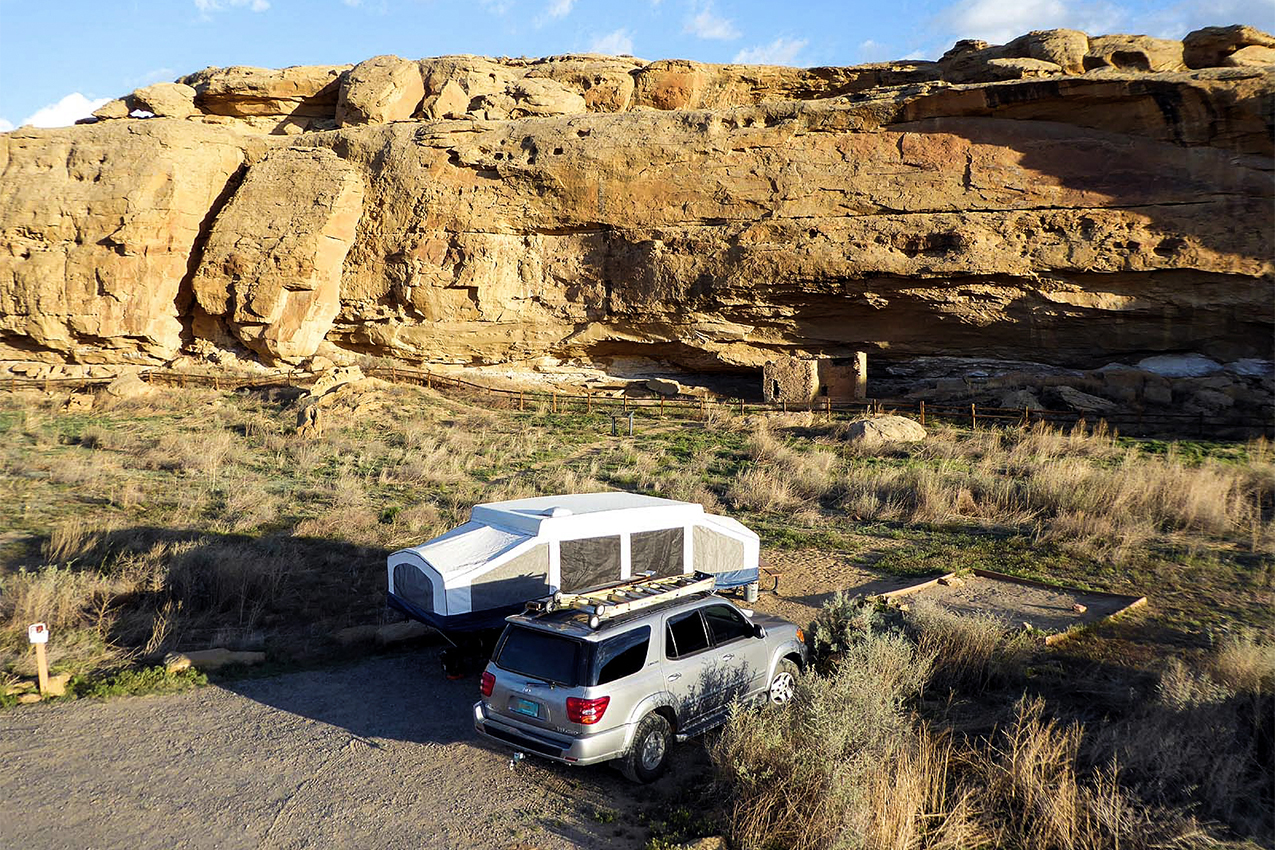 RV parked next to canyon rocks.