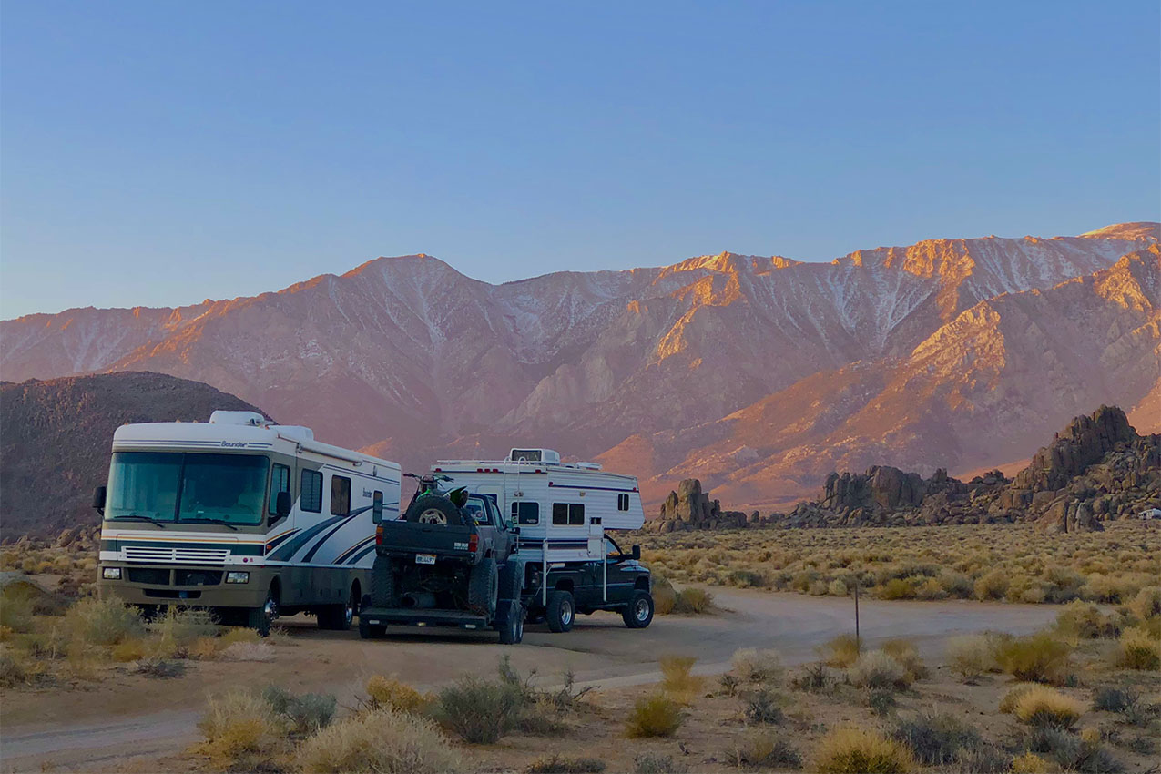 Couple of RVs parked amongst rocks.