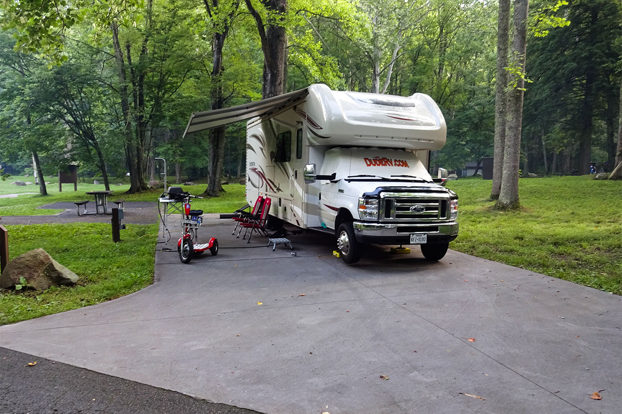Class C parked in a paved campsite.