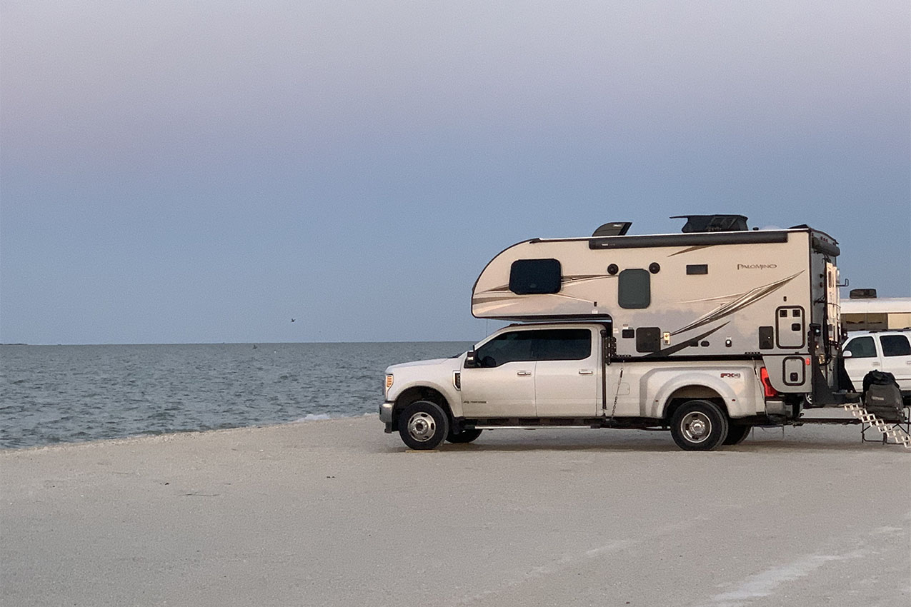 Truck camper parked on a beach.