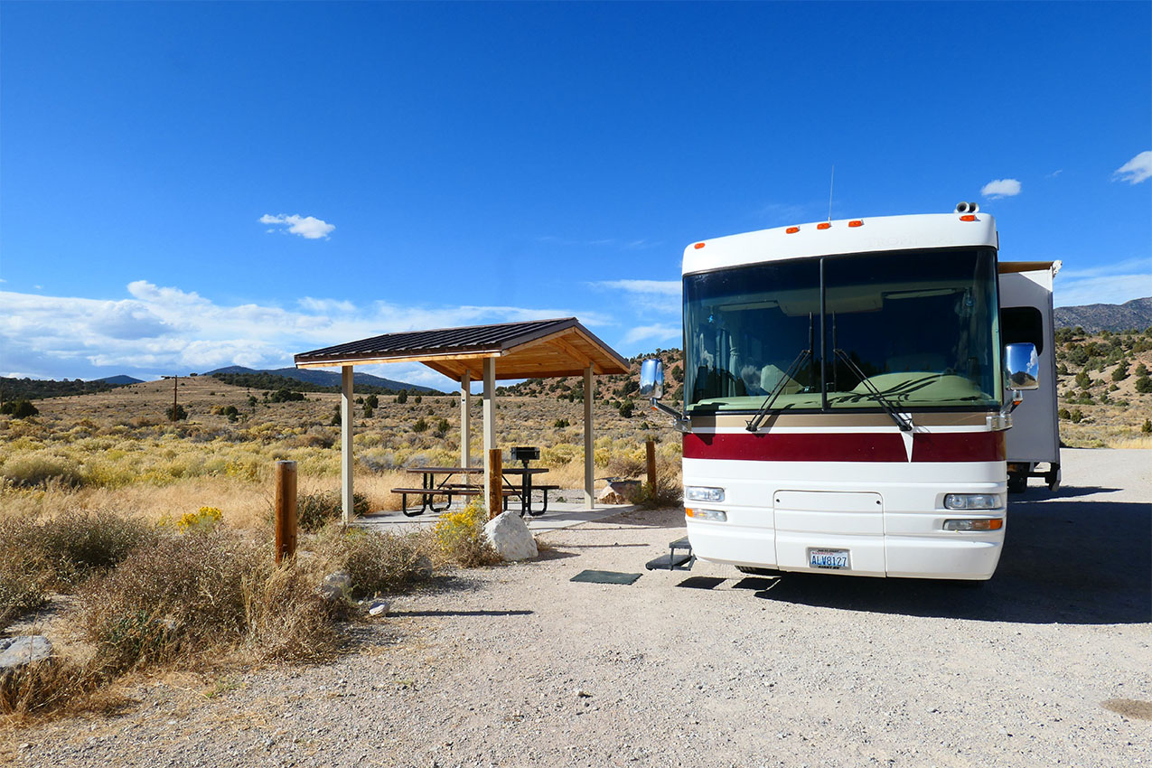 Class A parked next to a picnic shelter.