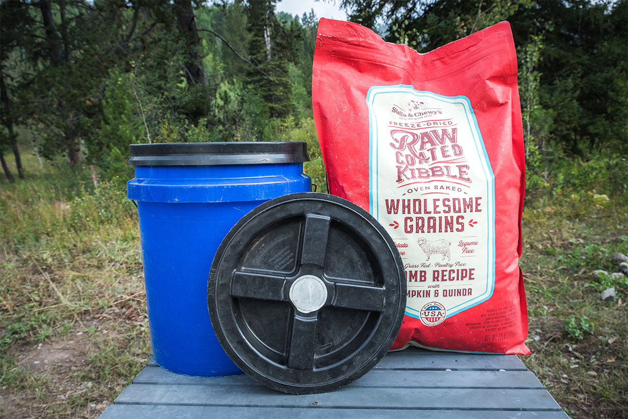 Dog food container next to a bag of dog food.