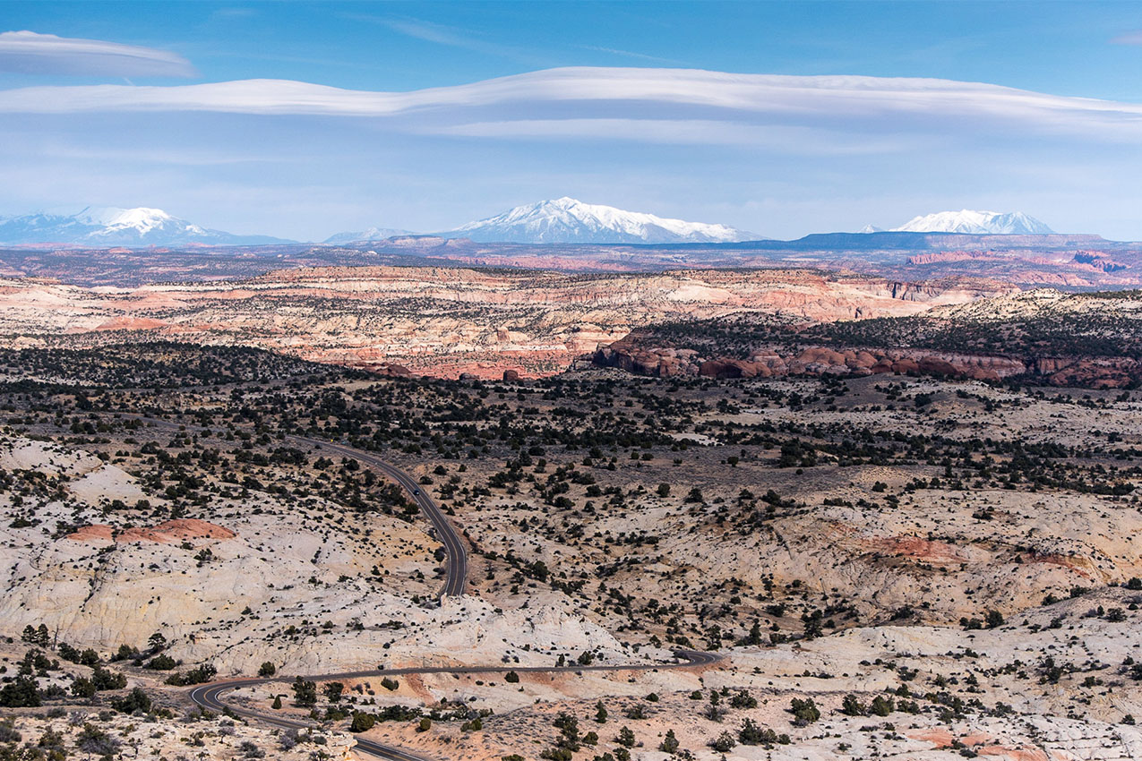 Aerial view of endless red rocks with a road through it.