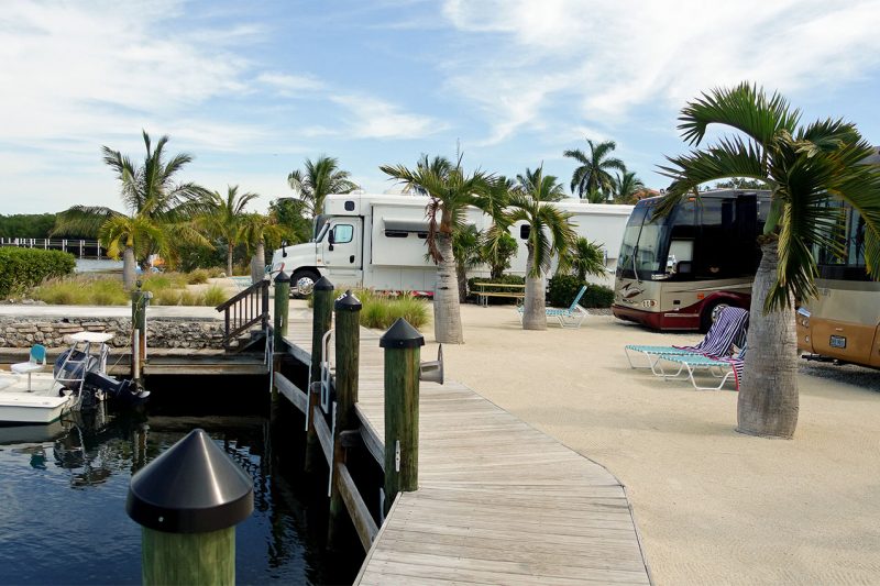 Several class As parked in front of a boat dock.