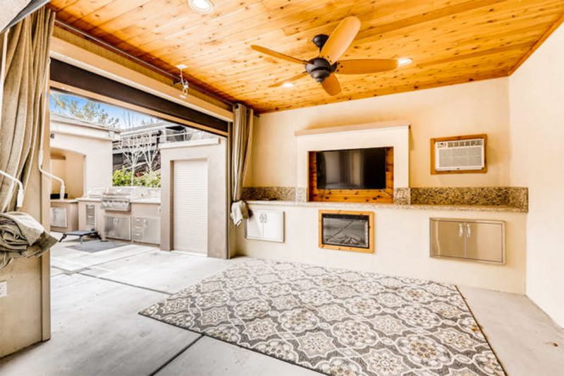 A wooden ceiling cabana with a TV screen next to an RV site.