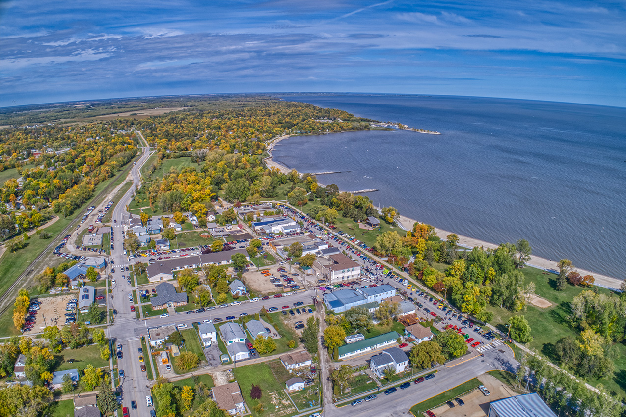 Aerial view of houses, fall colored trees, and the ocean.