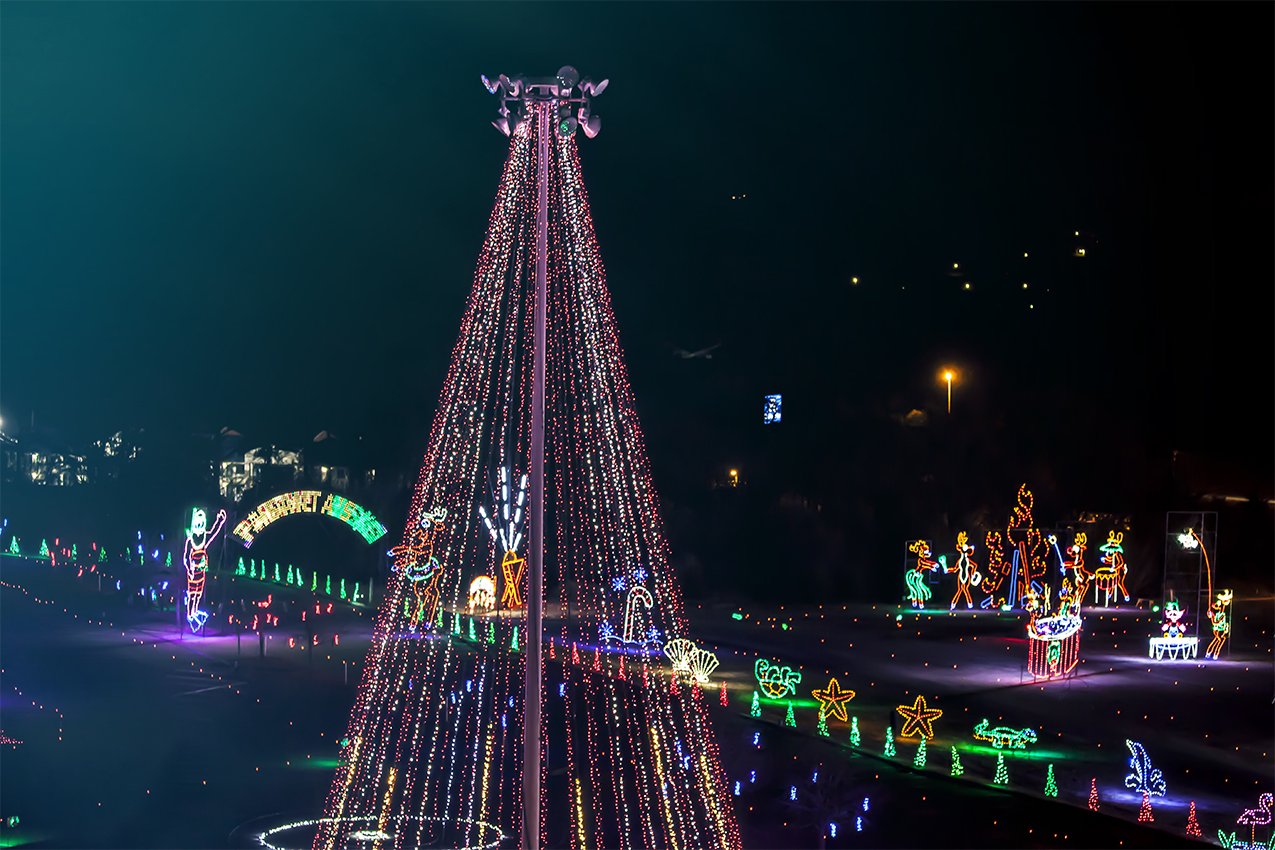 Christmas tree light along with other holiday decorations along a street.