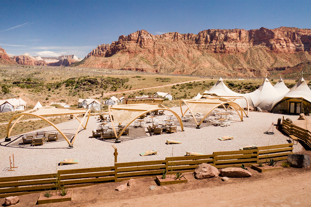 Lounge chairs under cabanas surrounded by canvas tents and Utah's red rocks.