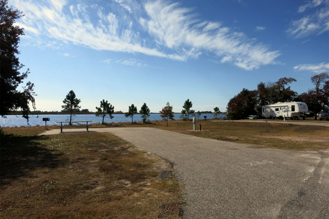 A campground with trees and a view of the water