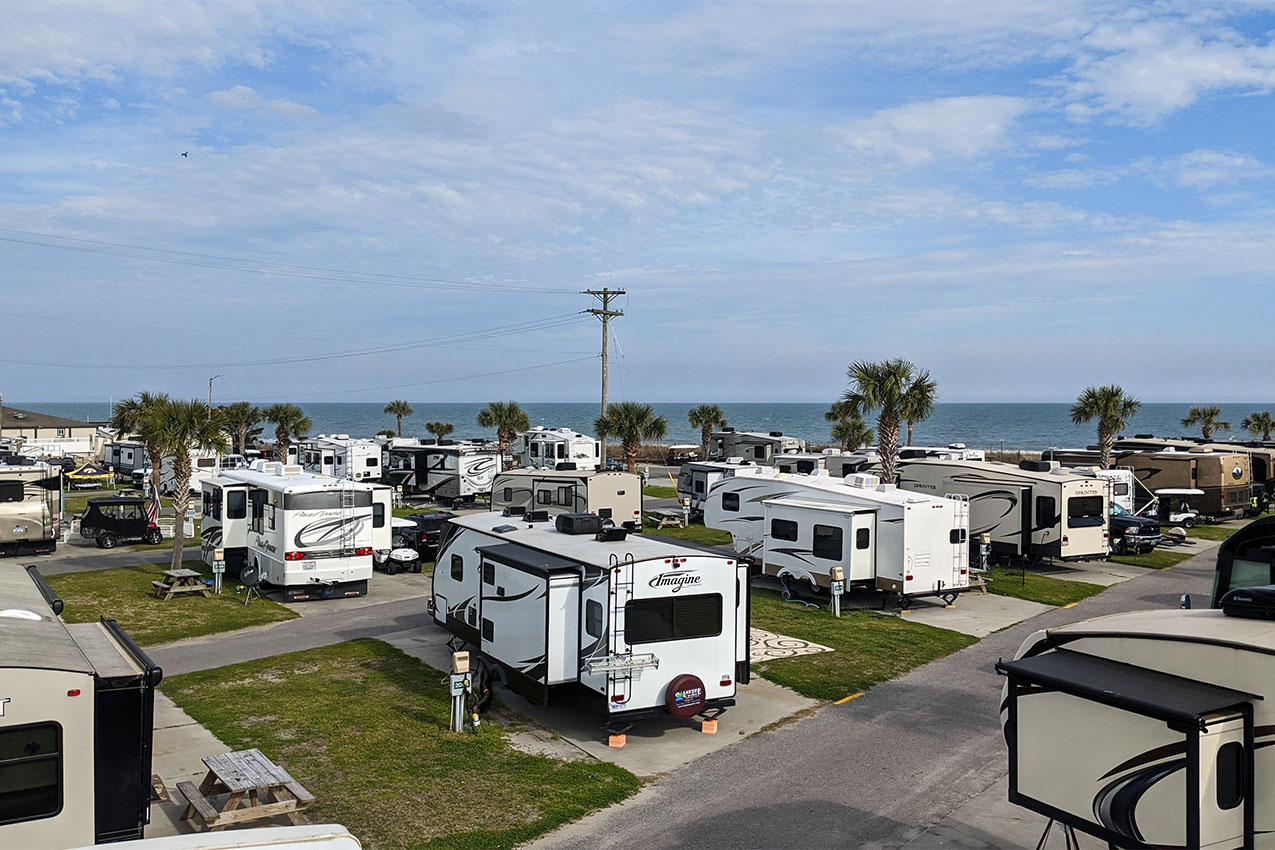 Rows of RV at an RV park right by the ocean.