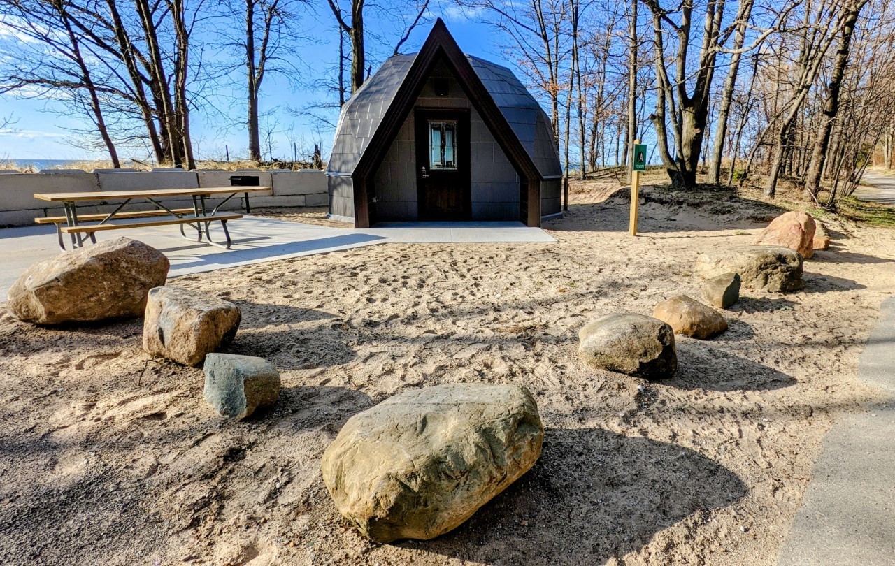 Pointed dome at sandy campsite near lake