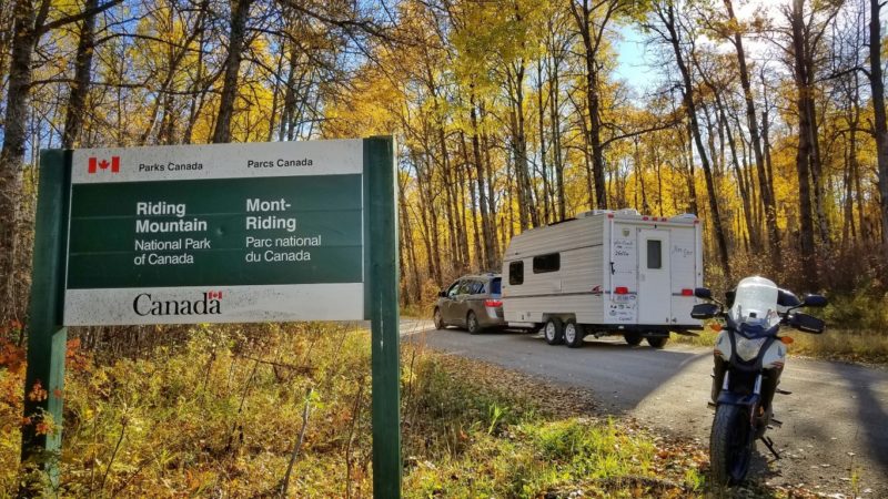 Trailer being towed by van in front of Parks Canada signage