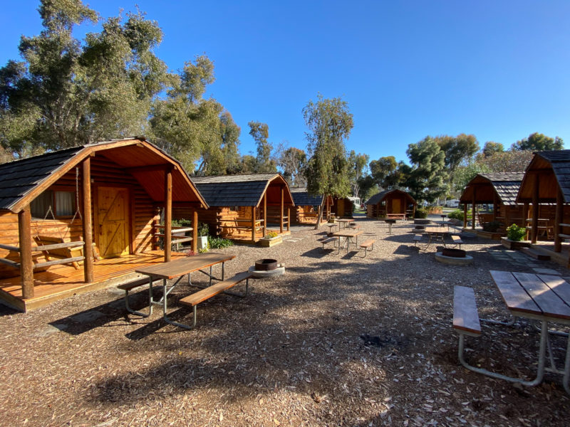 Wooded cabins at campground with picnic tables and fire rings