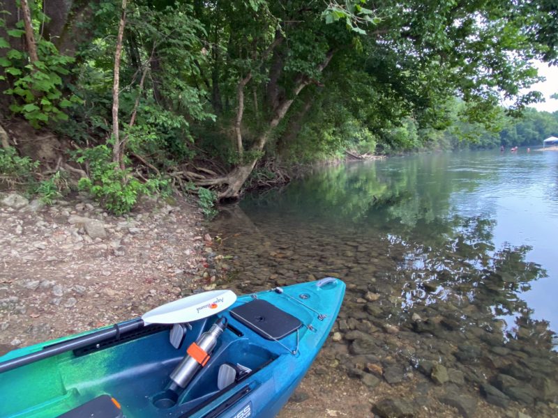 Kayak sitting on the bank of a body of water, ready to launch