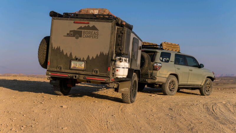 Toyota 4 Runner pulling an overlanding RV on a dirt road