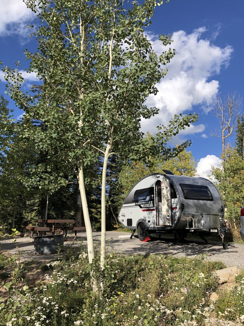 Teardrop trailer parked in a wooded area at a campground