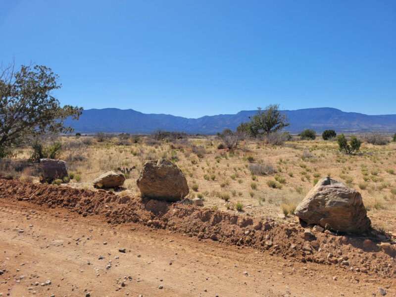 Dirt road in Arizona national forest with boulders lining roadway