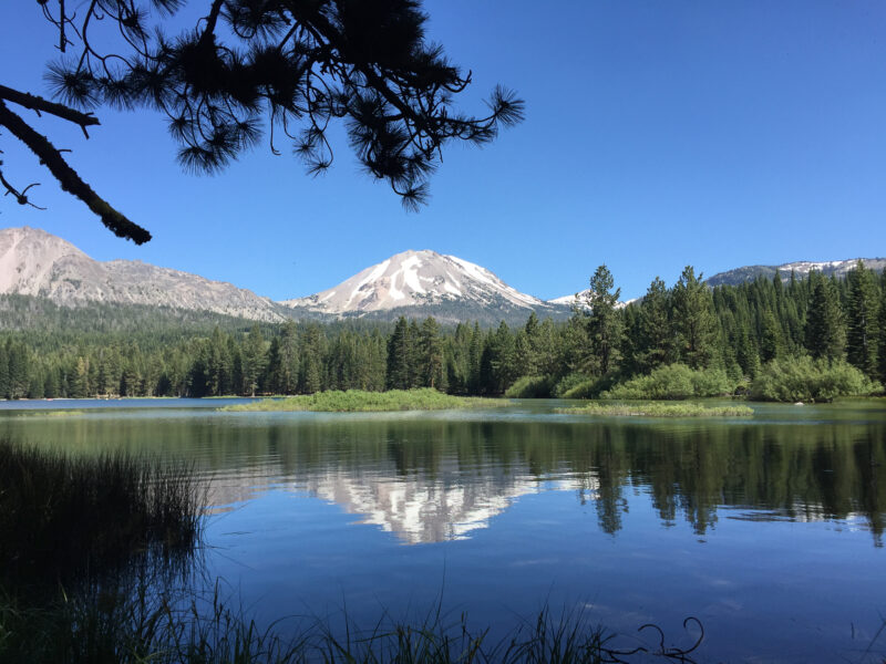 View of a lake with mountains and woods in the background