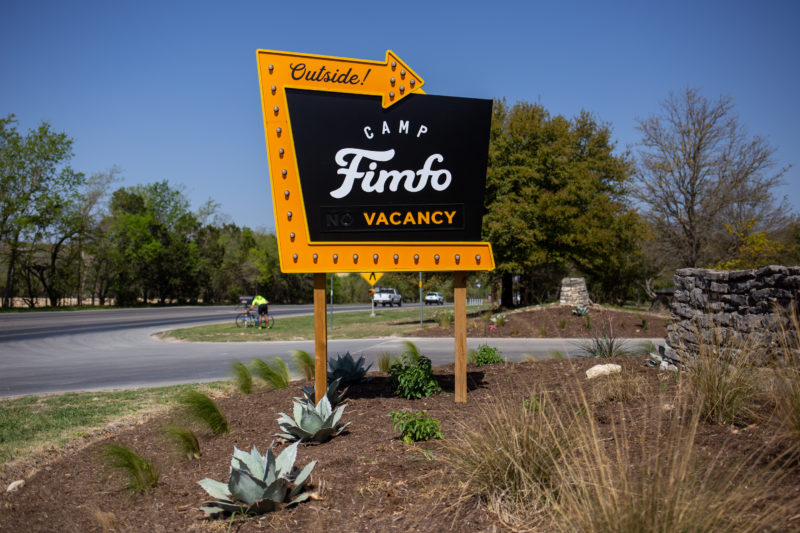 a yellow and brown entrance sign for camp fimfo