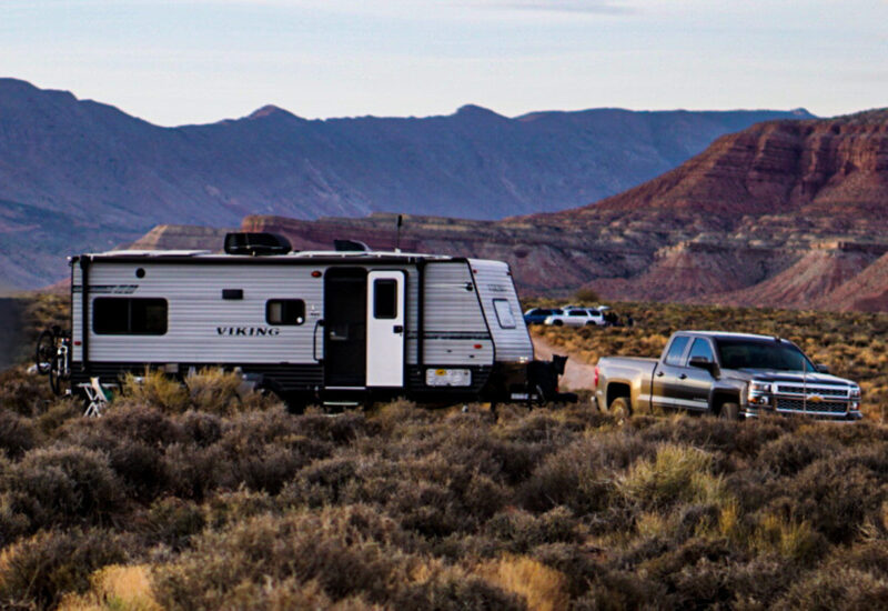 a truck tows an rv near red rocks in utah