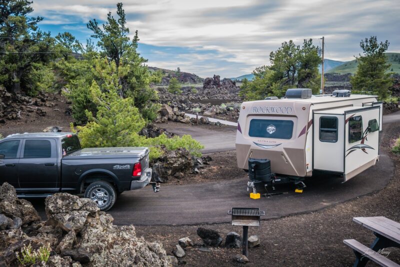 a truck tows an rv on a winding road