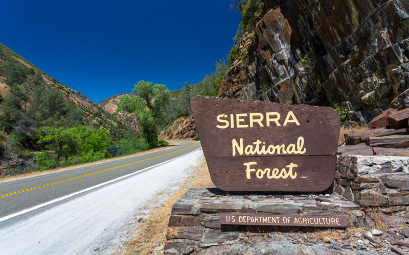 Yosemite National Park sign on winding road in mountains
