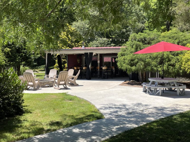 Gathering area with a fire pit and picnic tables at a campground