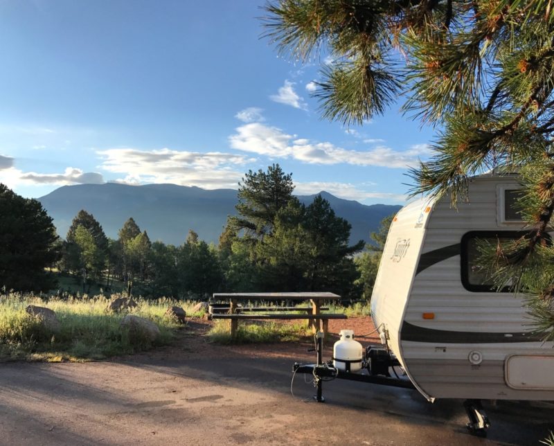 a trailer is parked at a campsite with a picnic table without hills in the background