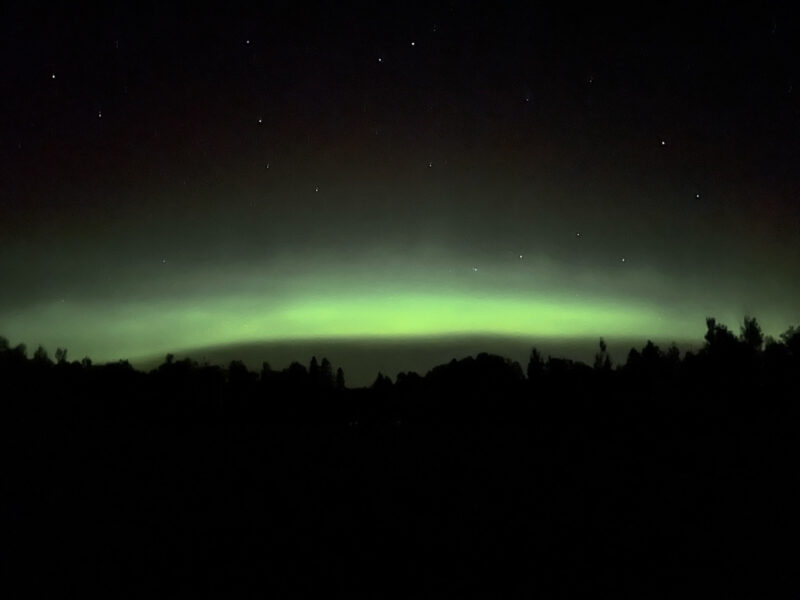 green streaks of the northern lights against a dark night sky