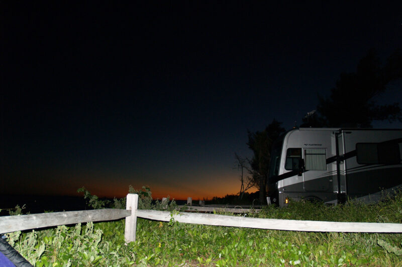 an RV parked at a campsite at night
