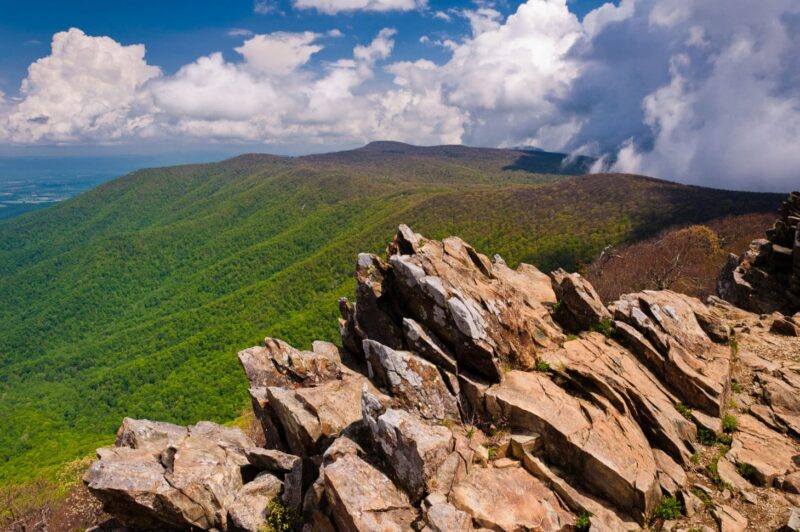 Jagged rocky peak overlooking green hills