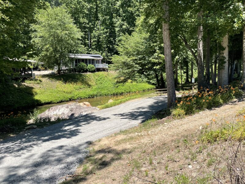 RV campsite along a river with a gravel pad