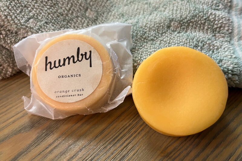 Two orange conditioner bars next to a bath towel