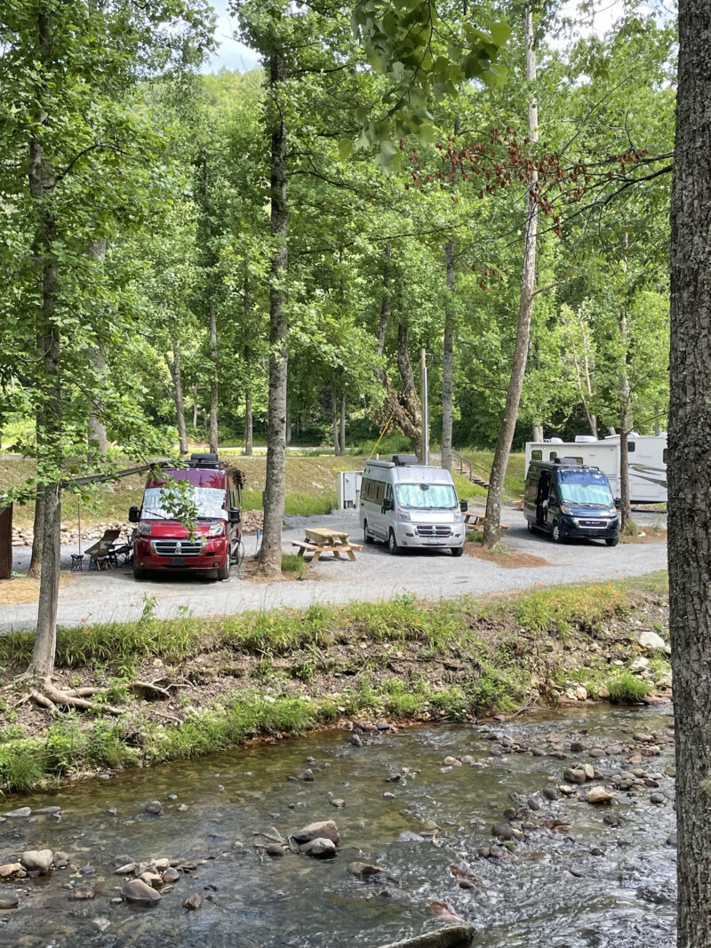 Vans parked for camping along a river