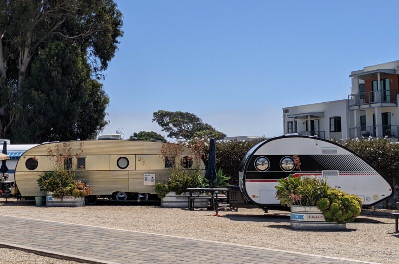 two tear drop trailers parked at a campground