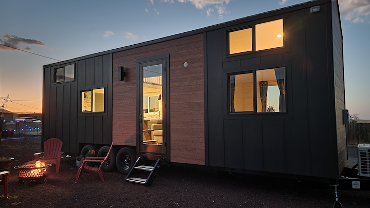 a tiny home lit up at dusk